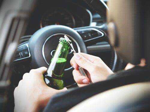 person opening a beer while driving