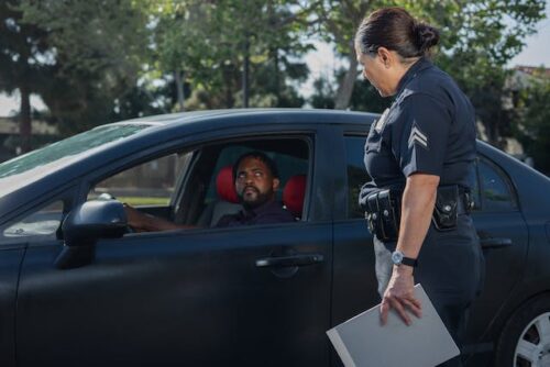 police woman talking to man in car