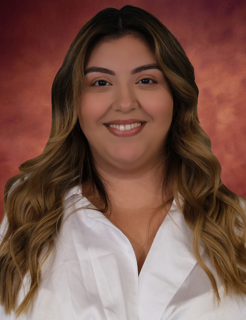 Rosy Balderas, with long wavy hair, smiles warmly in a white shirt against a marbled backdrop.