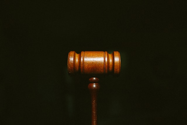 A wooden gavel is centered against a dark background, symbolizing justice and authority, often evoked in cases like a third DWI.