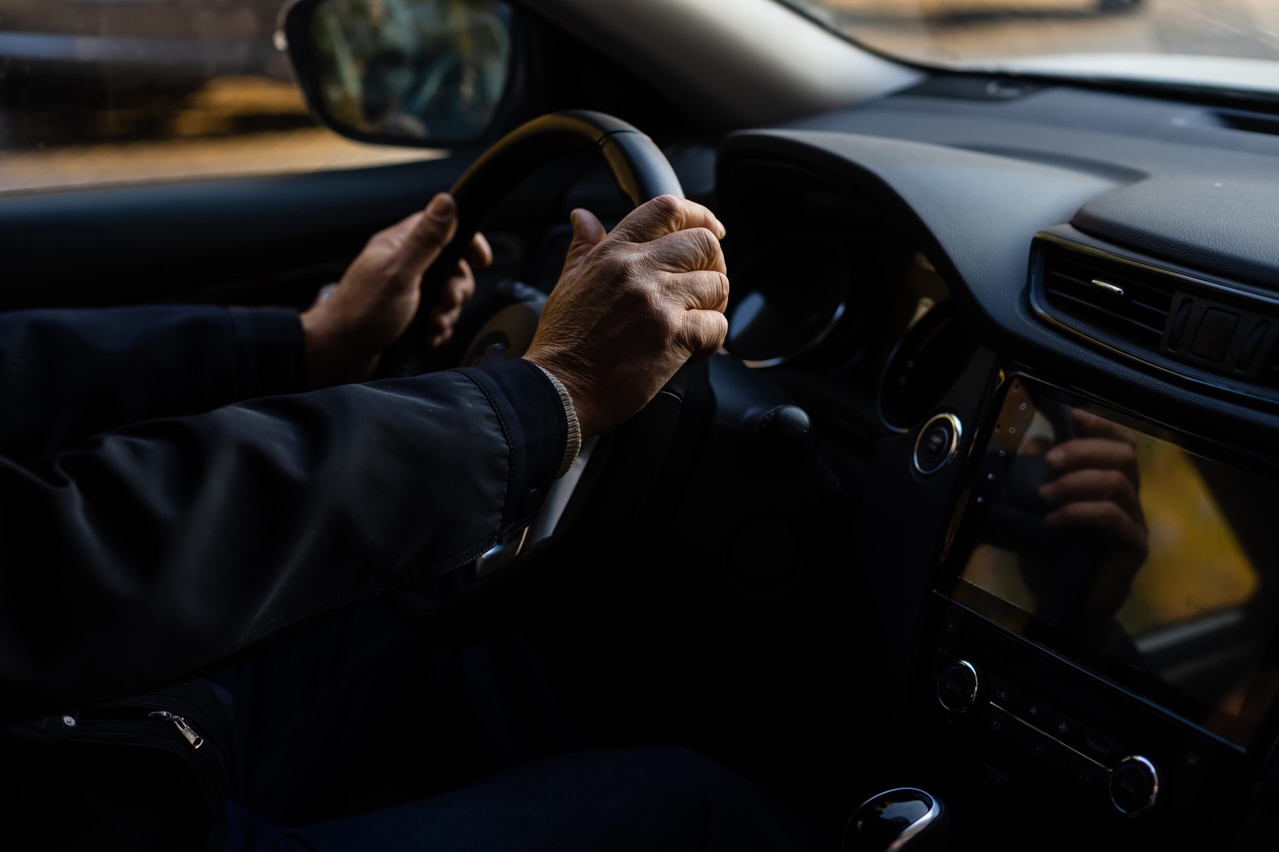 Elderly person driving a car. elderly man in a car
